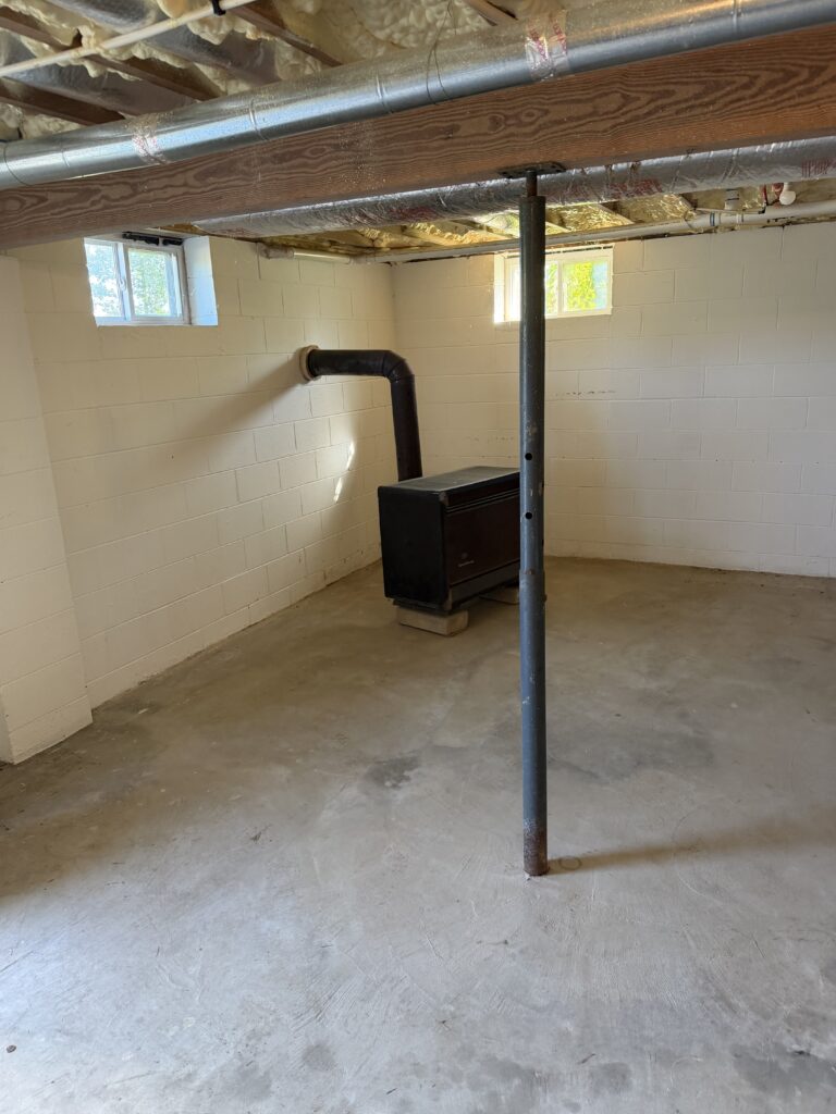 After basement junk removal in Blairsville, Georgia, showing the cleared concrete floor and open space following furniture and unwanted-item removal by Appalachian Junk Removal, LLC.