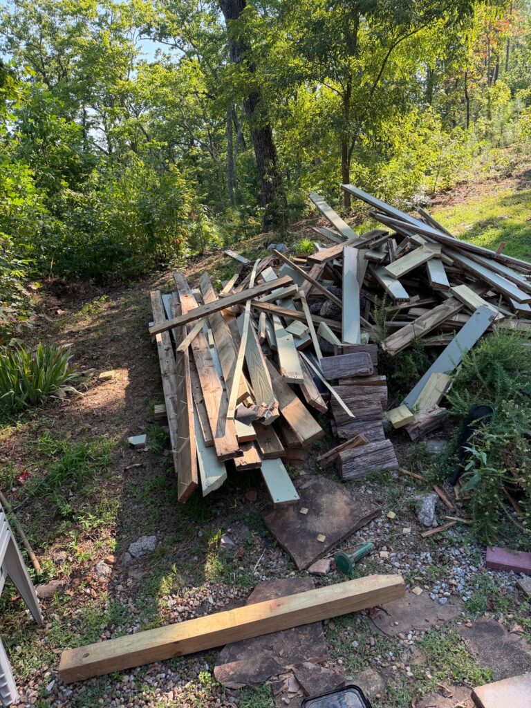 BEFORE — Large pile of lumber, railing, and construction debris from a deck replacement awaiting removal by Appalachian Junk Removal, LLC in Clayton, Georgia.
